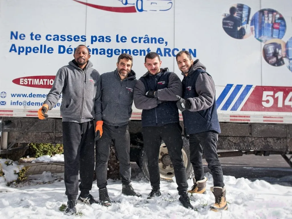 Quatre membres de l’équipe Déménagement Arcan devant leur camion